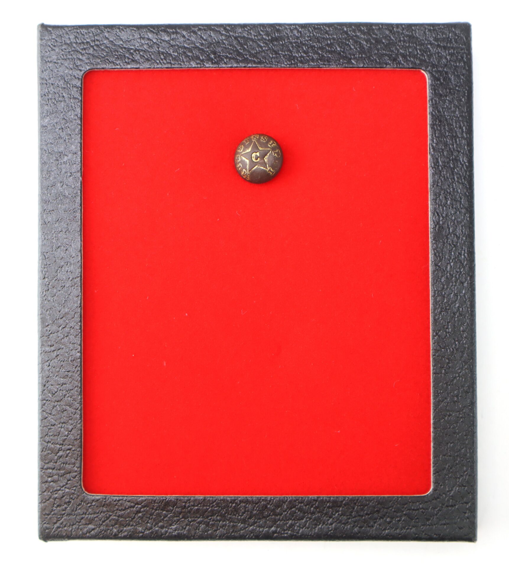 A Mississippi Cavalry Button is displayed on a bright red felt background inside a black frame case.