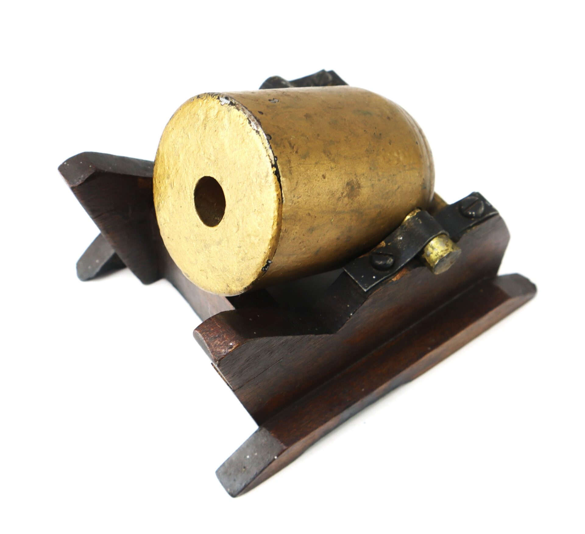 Brass signal cannon mounted on a wooden base, viewed from the front, showing the cannon’s muzzle and support structure.