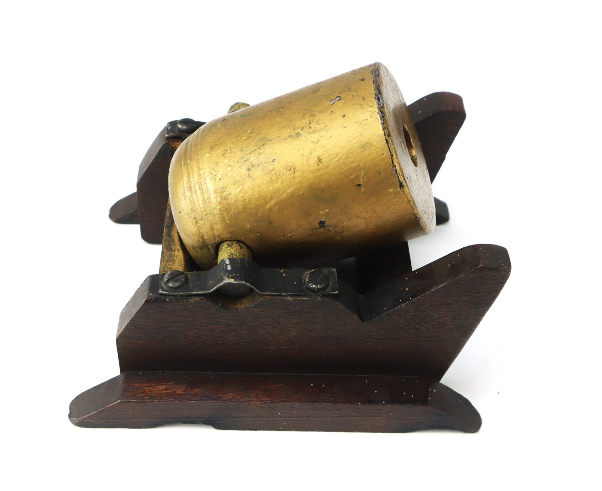 Small brass cannon model mounted on a dark wooden base, viewed from an angle against a white background.