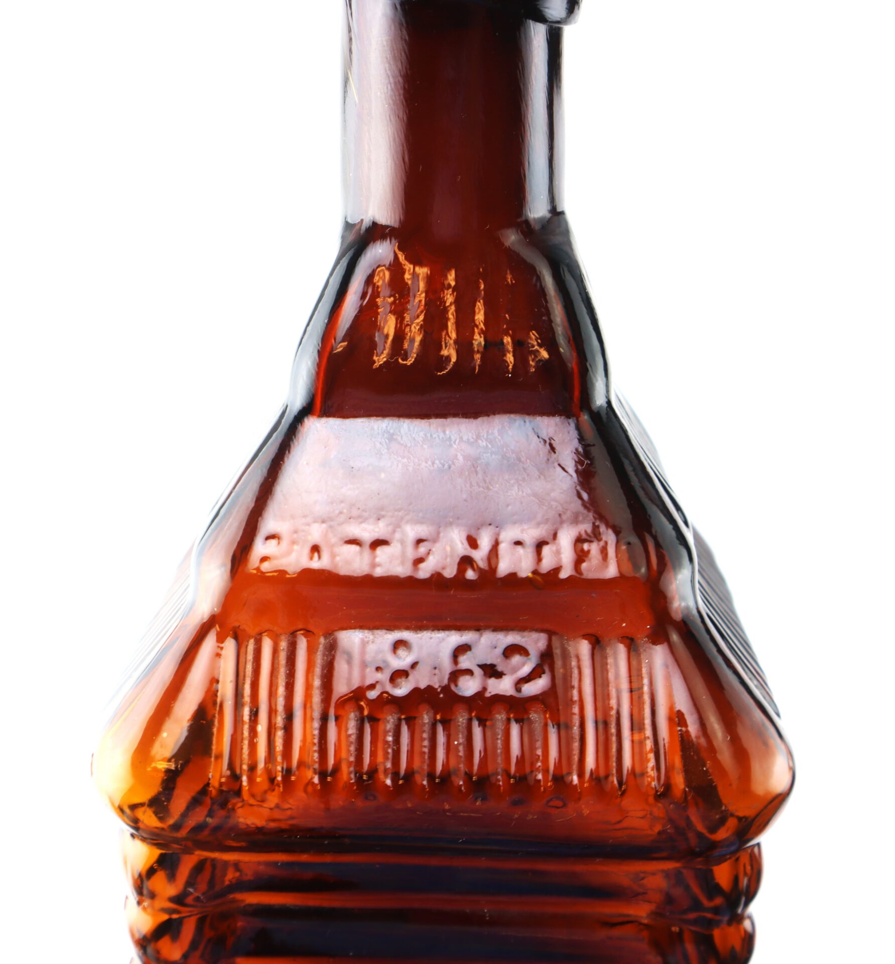 Close-up of the neck and upper body of a brown glass bottle with embossed text reading “PATENTED 1862” on its surface.