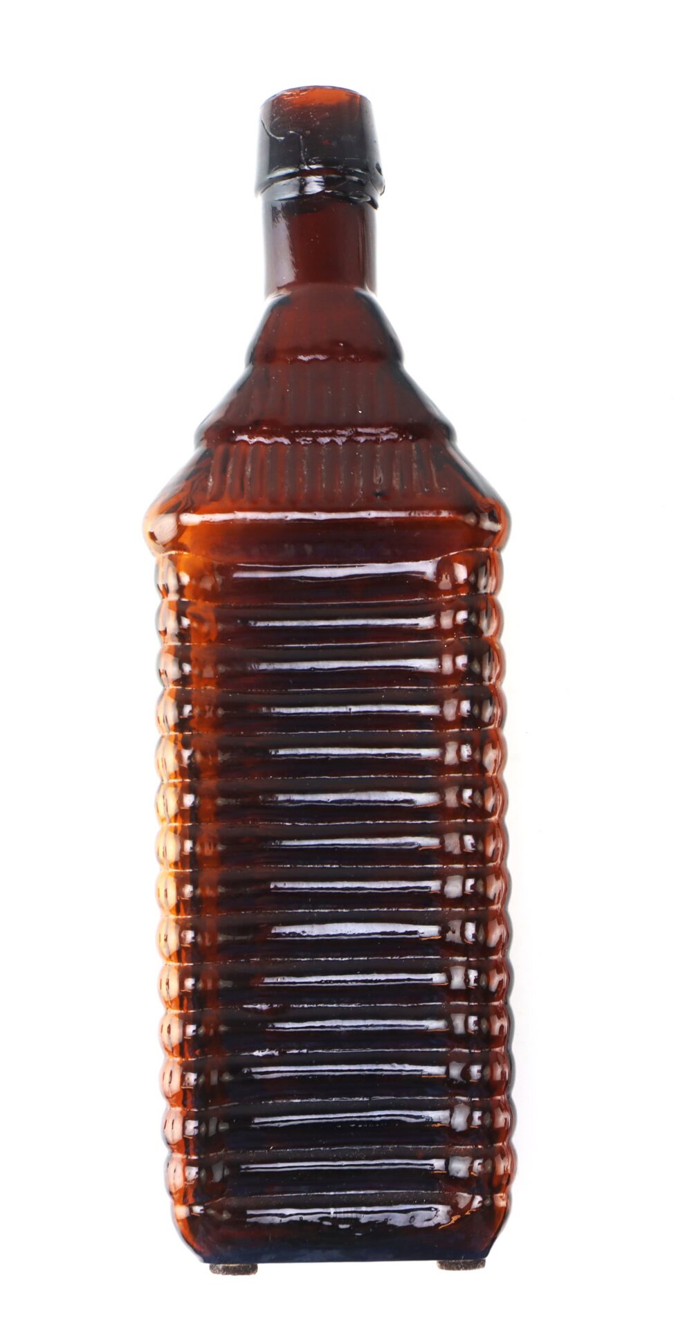 A ribbed, rectangular brown glass bottle with a narrow neck and a slightly tilted cap, photographed on a white background.