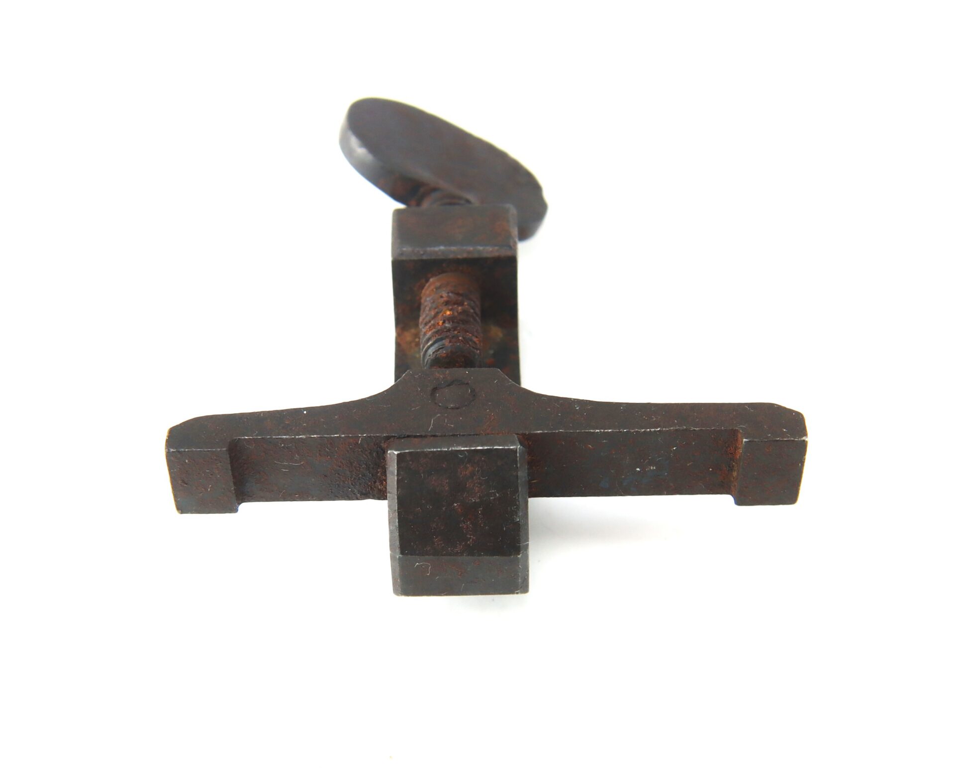 A rusted metal tool with a T-shaped handle and a square central piece, photographed against a white background.