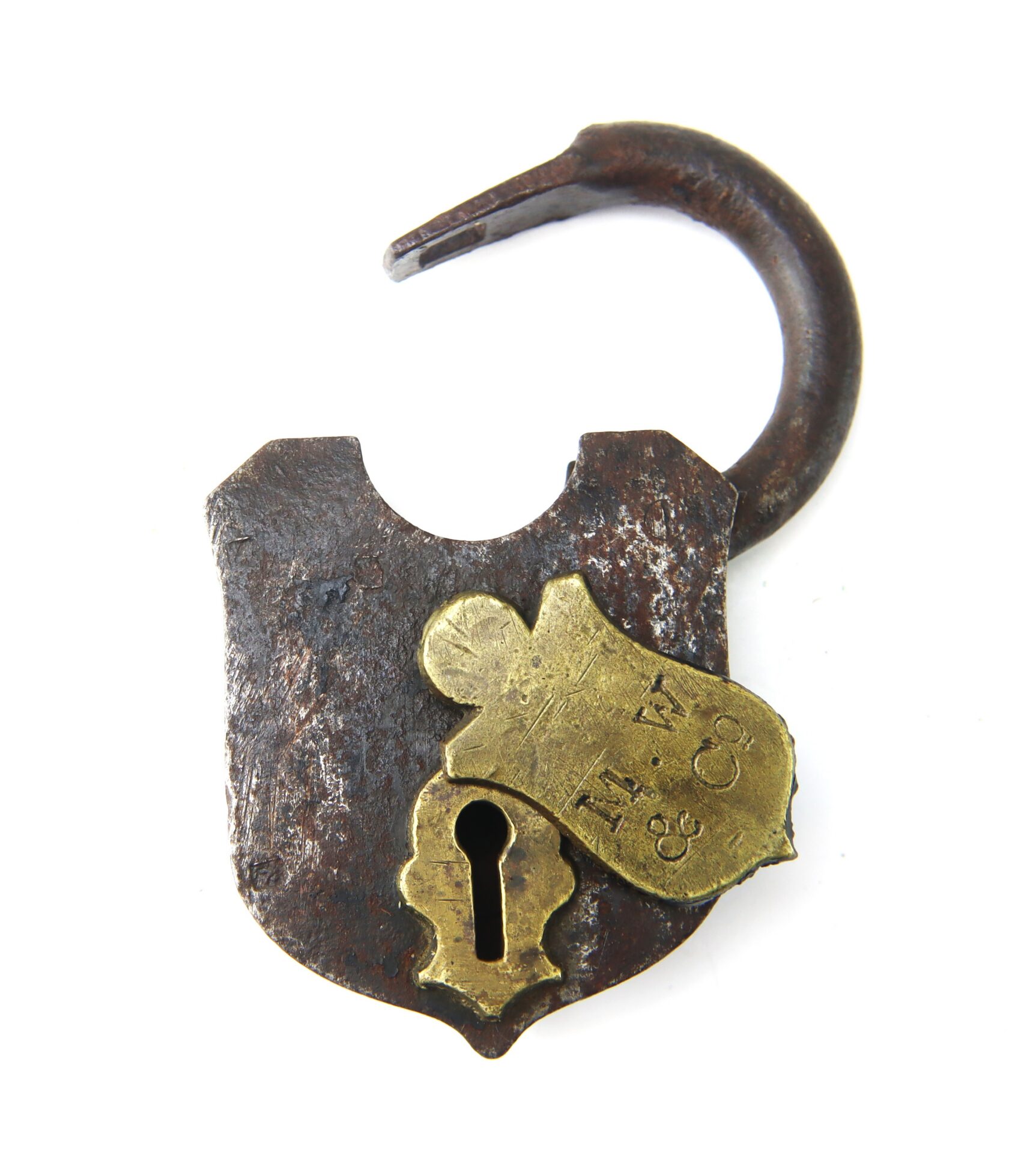 Old, rusted padlock with a partially broken brass plate, engraved with “M. W. & Co.,” and an open shackle. The keyhole is visible at the bottom of the lock.