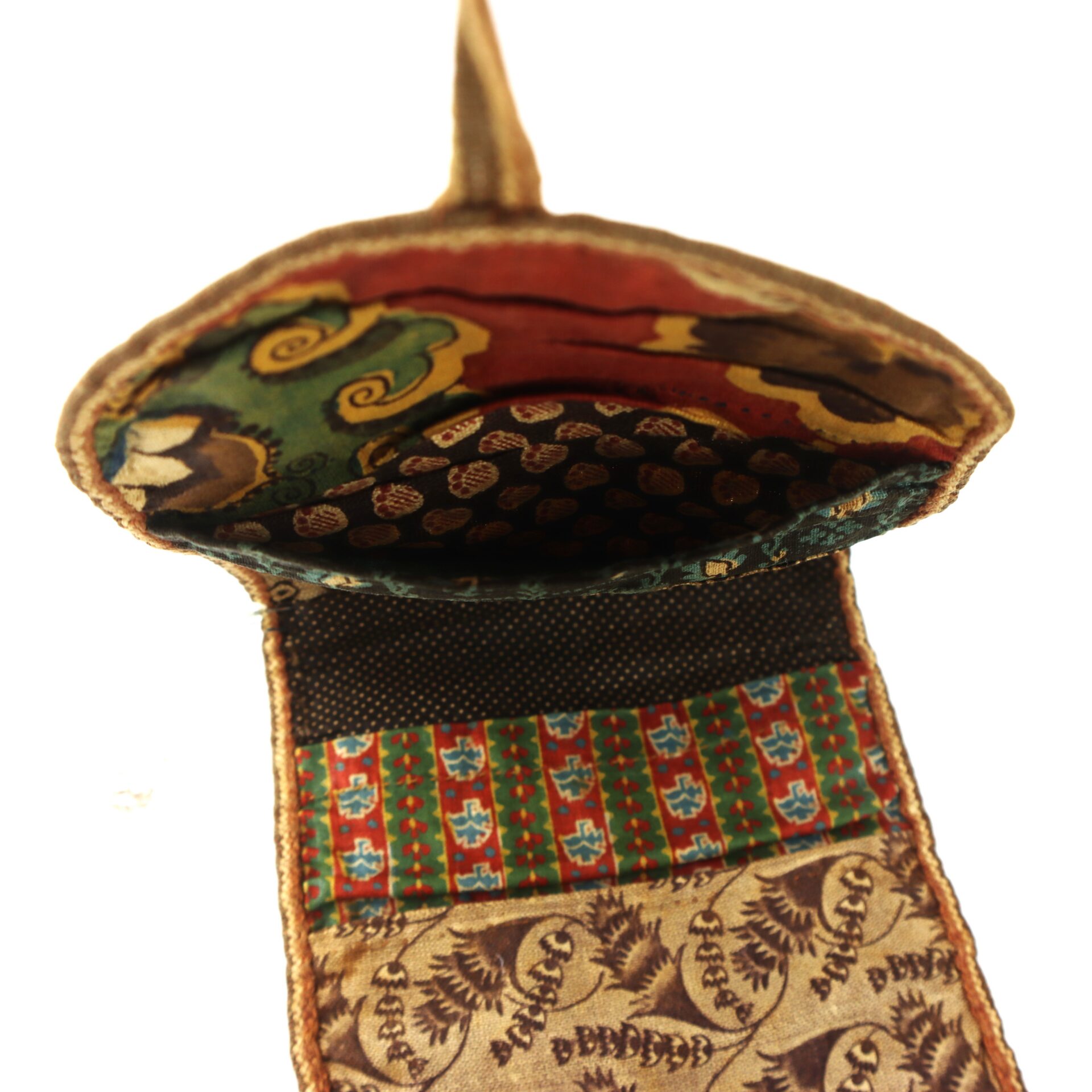 A fabric pouch with a flap open, showing multiple colorful patterned sections and various textile designs inside and outside.