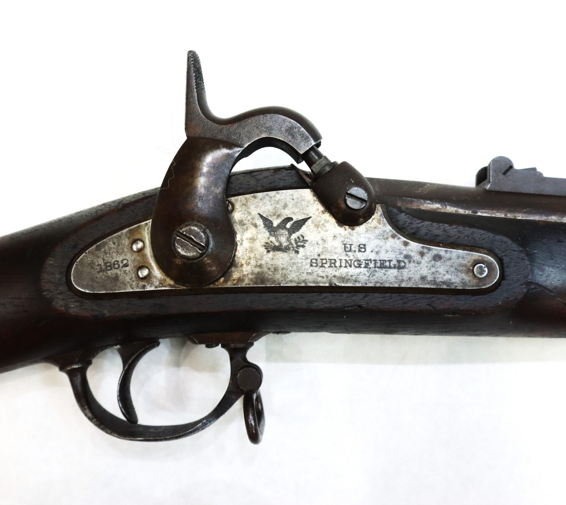 Close-up of the lock mechanism of a U.S. Springfield rifle, marked with an eagle, “U.S. SPRINGFIELD,” and dated 1862.