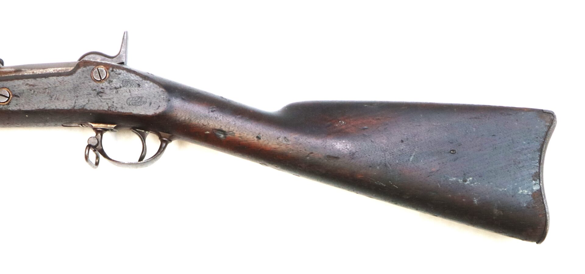 Close-up of an antique wooden rifle stock and trigger on a white background, showing signs of wear and aging.
