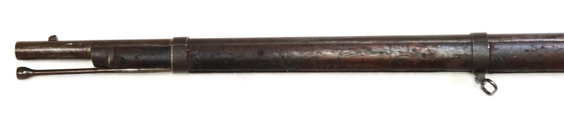 The image shows the barrel and wooden stock of an antique rifle with a ramrod underneath and metal bands securing the stock.