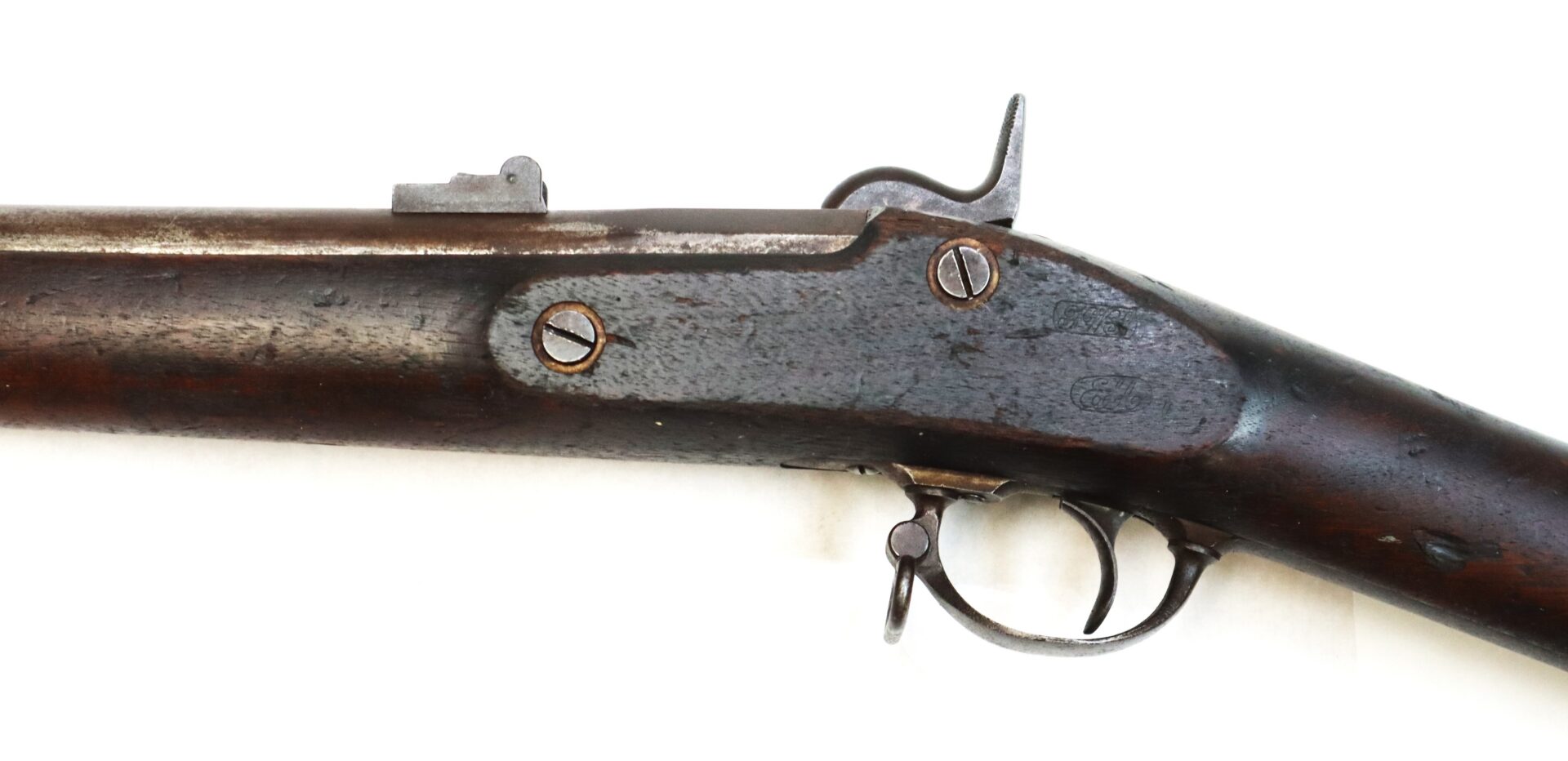 Side view of an old, weathered musket or rifle showing the trigger, trigger guard, and hammer against a white background.