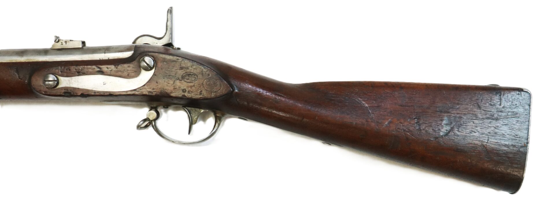 Close-up view of the wooden stock and metal lock mechanism of an antique rifle, showing wear and patina on both wood and metal surfaces.
