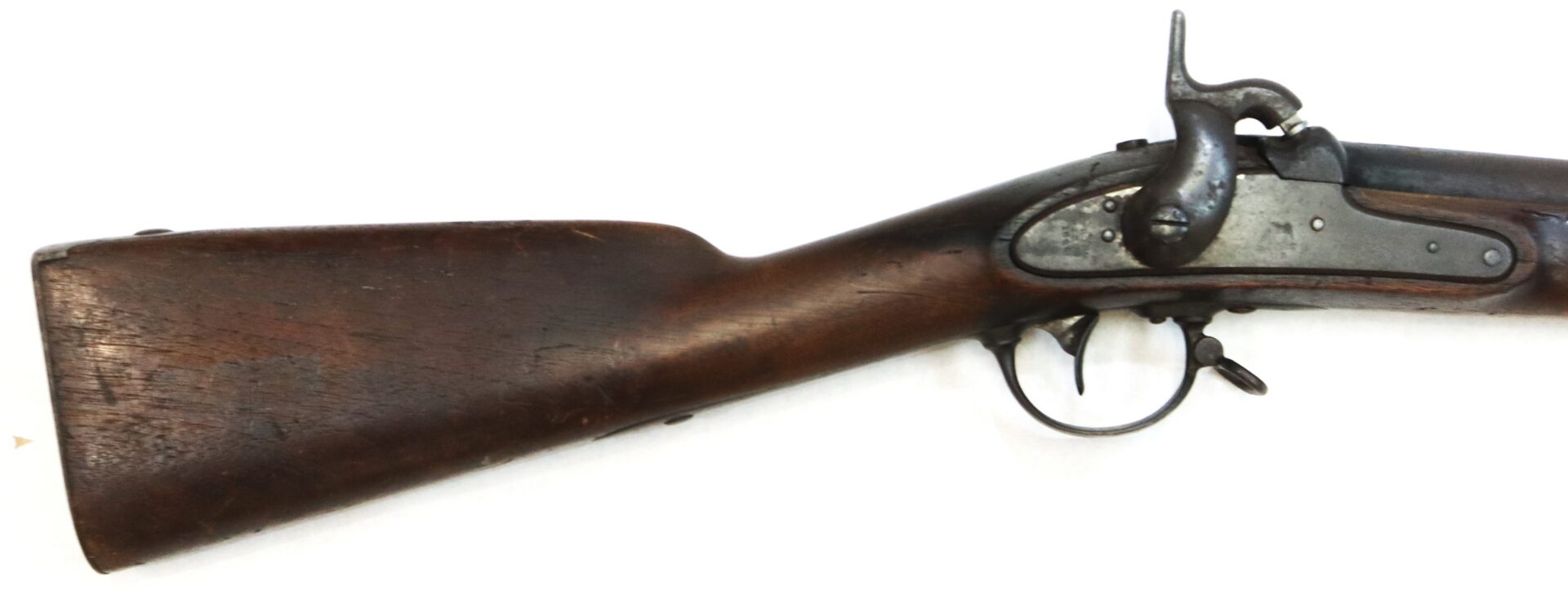 The image shows the stock and trigger section of an antique, muzzle-loading rifle with a wooden body and metal mechanisms.