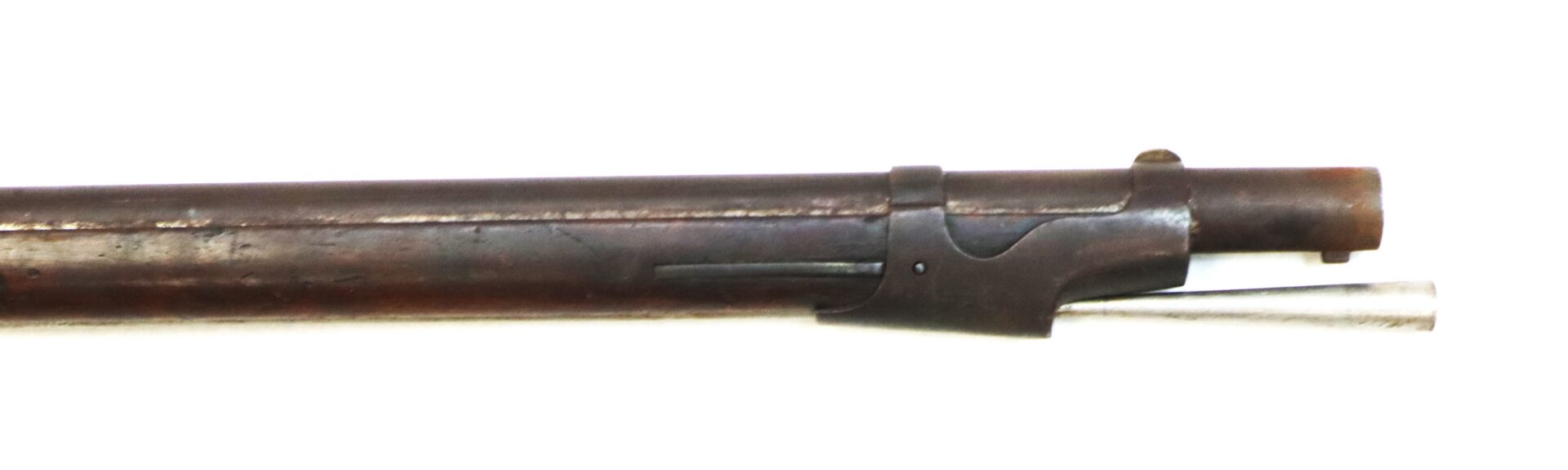 Close-up of the barrel and front sight of an antique rifle with a brown metal finish and a small metal rod beneath the barrel.