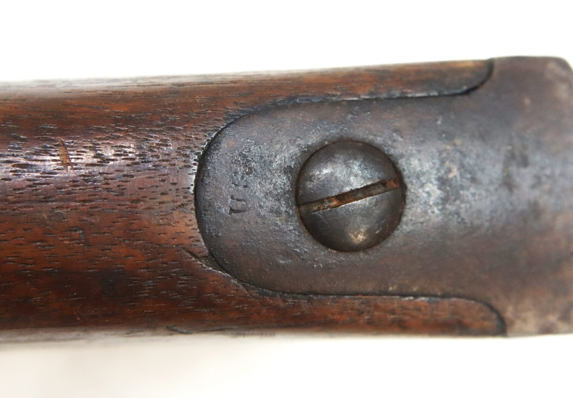 Close-up of a metal screw and plate stamped “U.S.” embedded in the wooden stock of a Model 1842 .69 Caliber Springfield Smoothbore Musket.