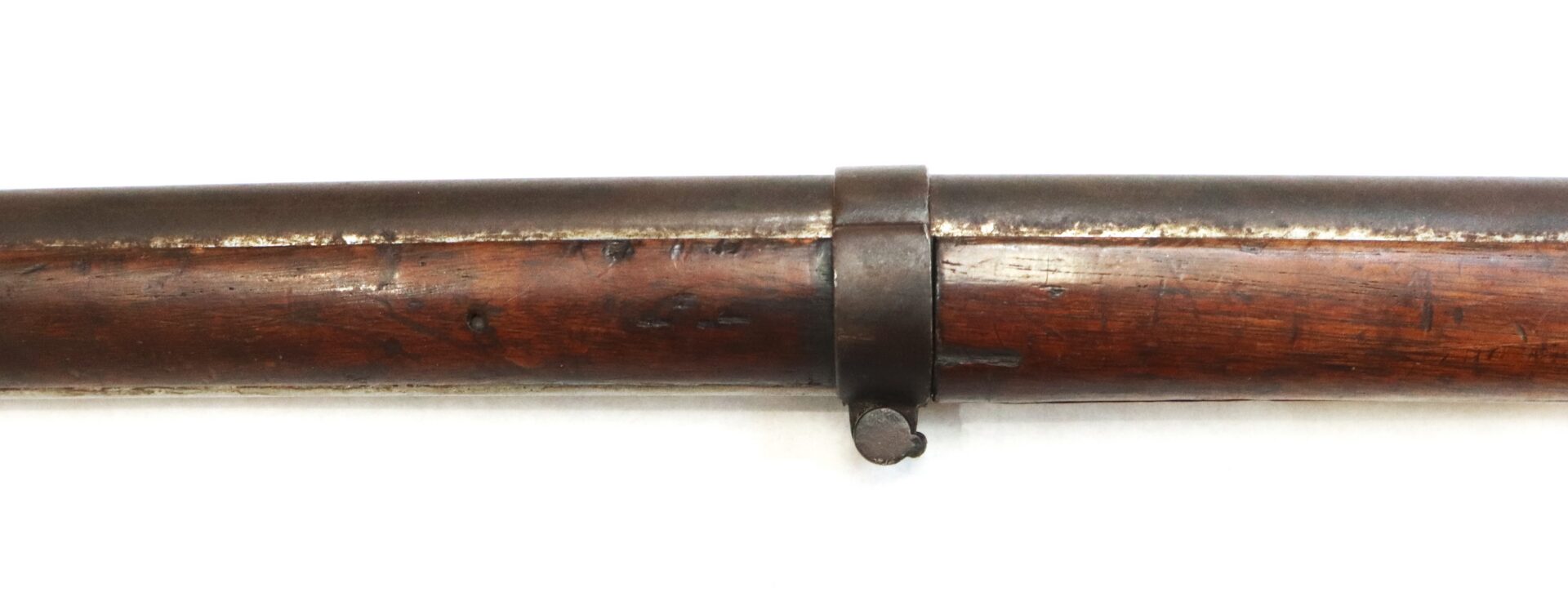 Close-up of a Model 1842 .69 Caliber Springfield Smoothbore Musket barrel secured to a dark wooden stock by a metal band with a small protruding loop.