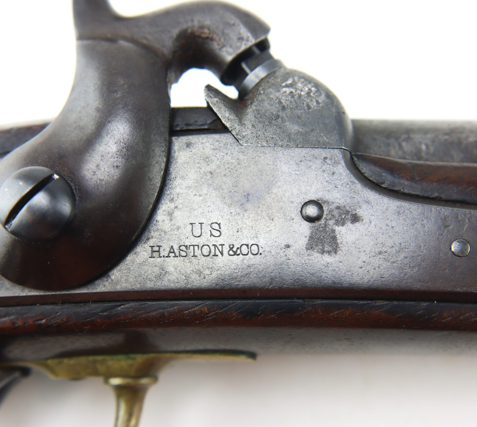 Close-up of a vintage firearm showing a metal plate engraved with “U.S HASTON & CO.” and part of the firing mechanism.