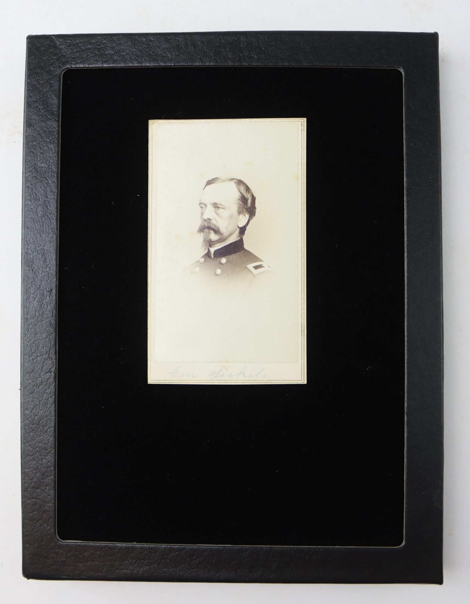 Sepia portrait of Major General Daniel E. Sickles in military uniform with shoulder epaulettes, by Fredricks & Co., mounted on a black mat with a rectangular opening.