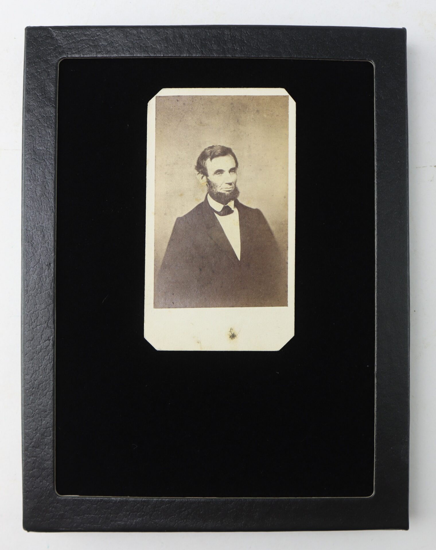 Sepia-toned portrait photograph of a man in a suit, displayed in a black rectangular frame with rounded corners.