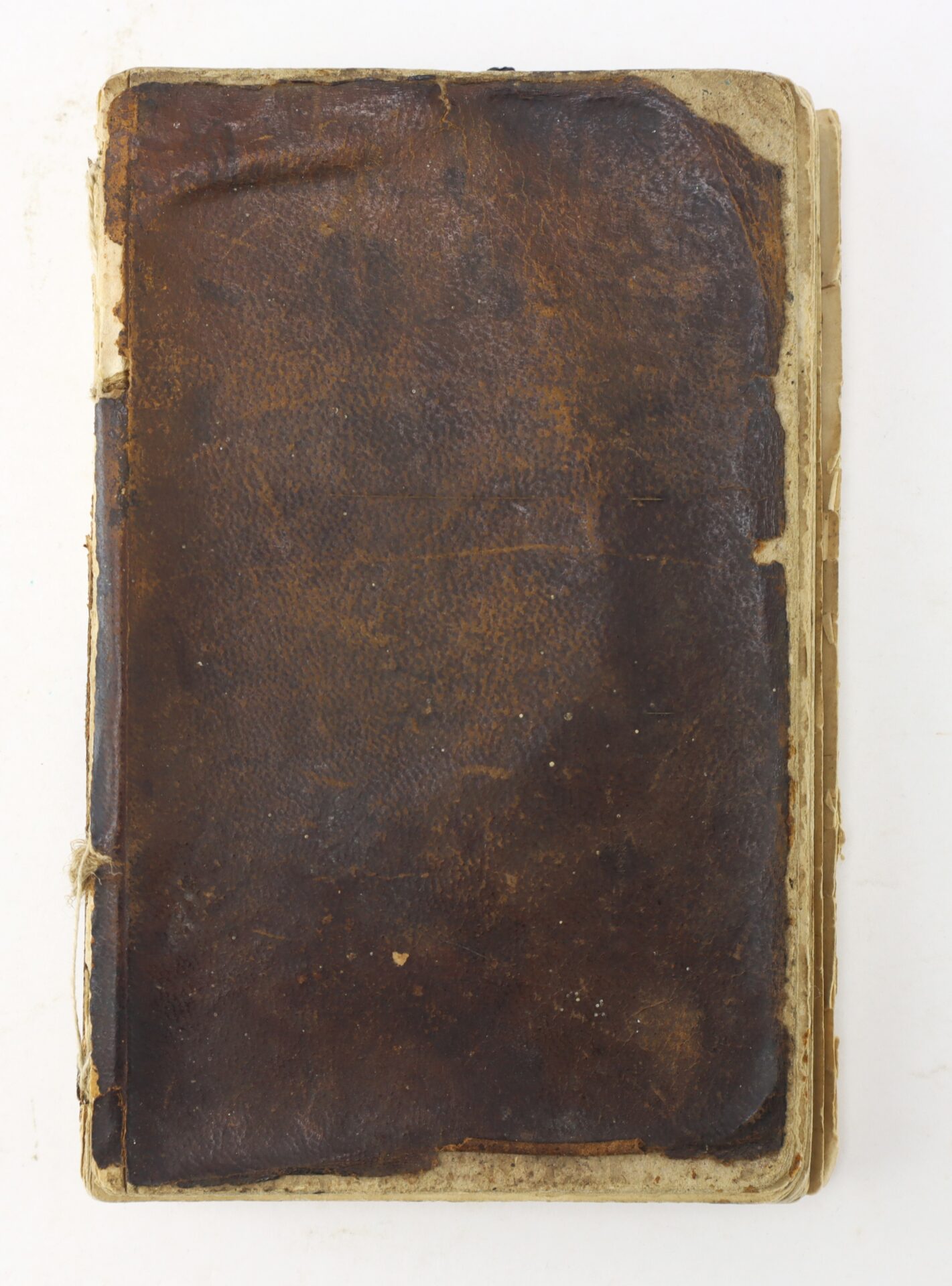 A worn, brown leather-covered book with frayed edges and visible signs of age, shown closed against a plain white background.