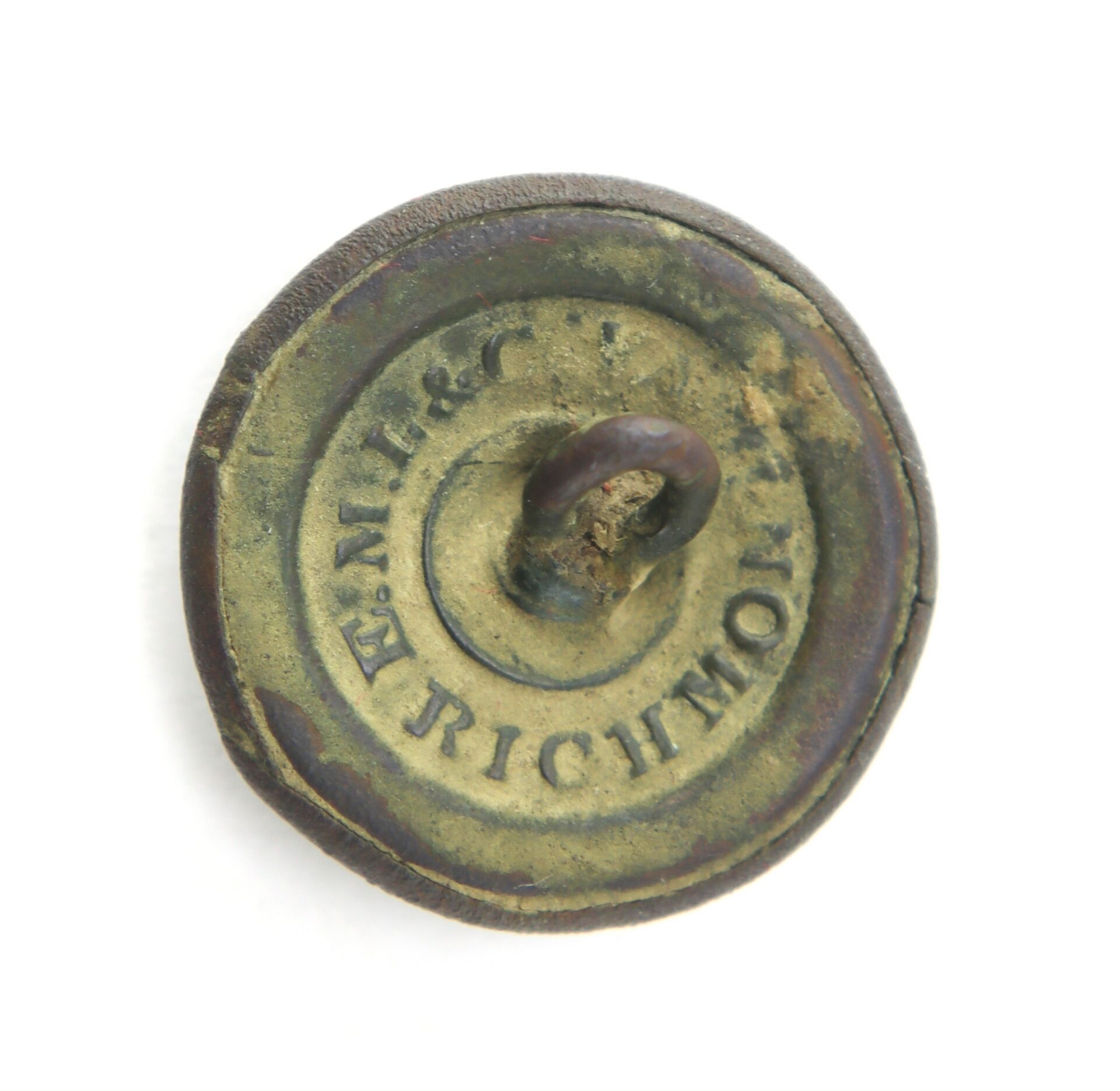 A round, weathered metal button with a loop shank and the inscription “E. M. 1860 RICHMOND” stamped on the back.