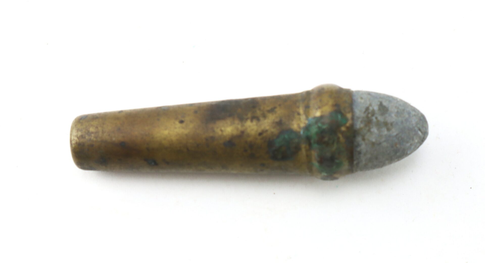 A single old, corroded bullet with a brass casing and a grayish pointed tip is shown against a plain white background.