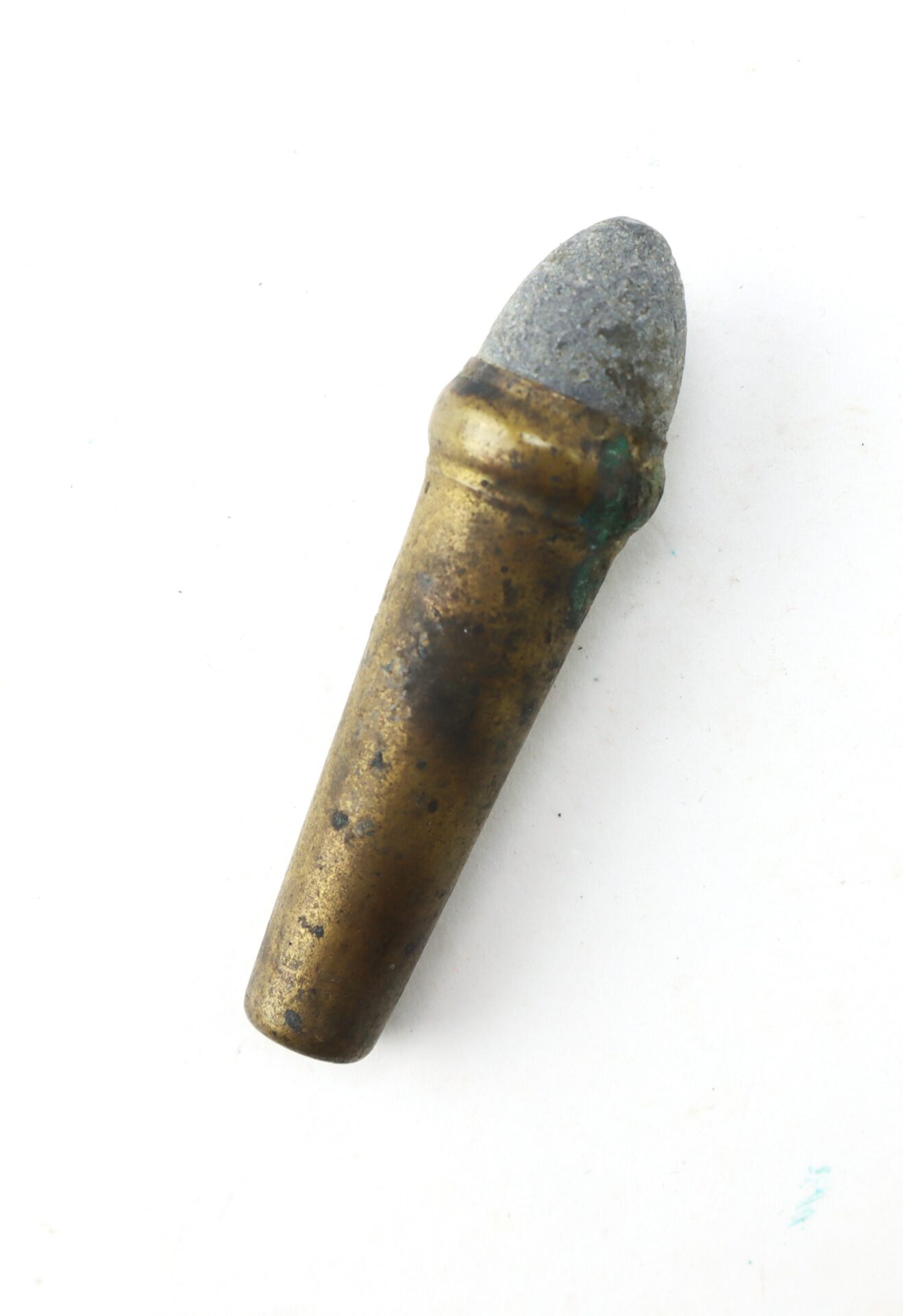 A single old bullet with a brass casing and a gray, rounded tip is displayed against a plain white background.