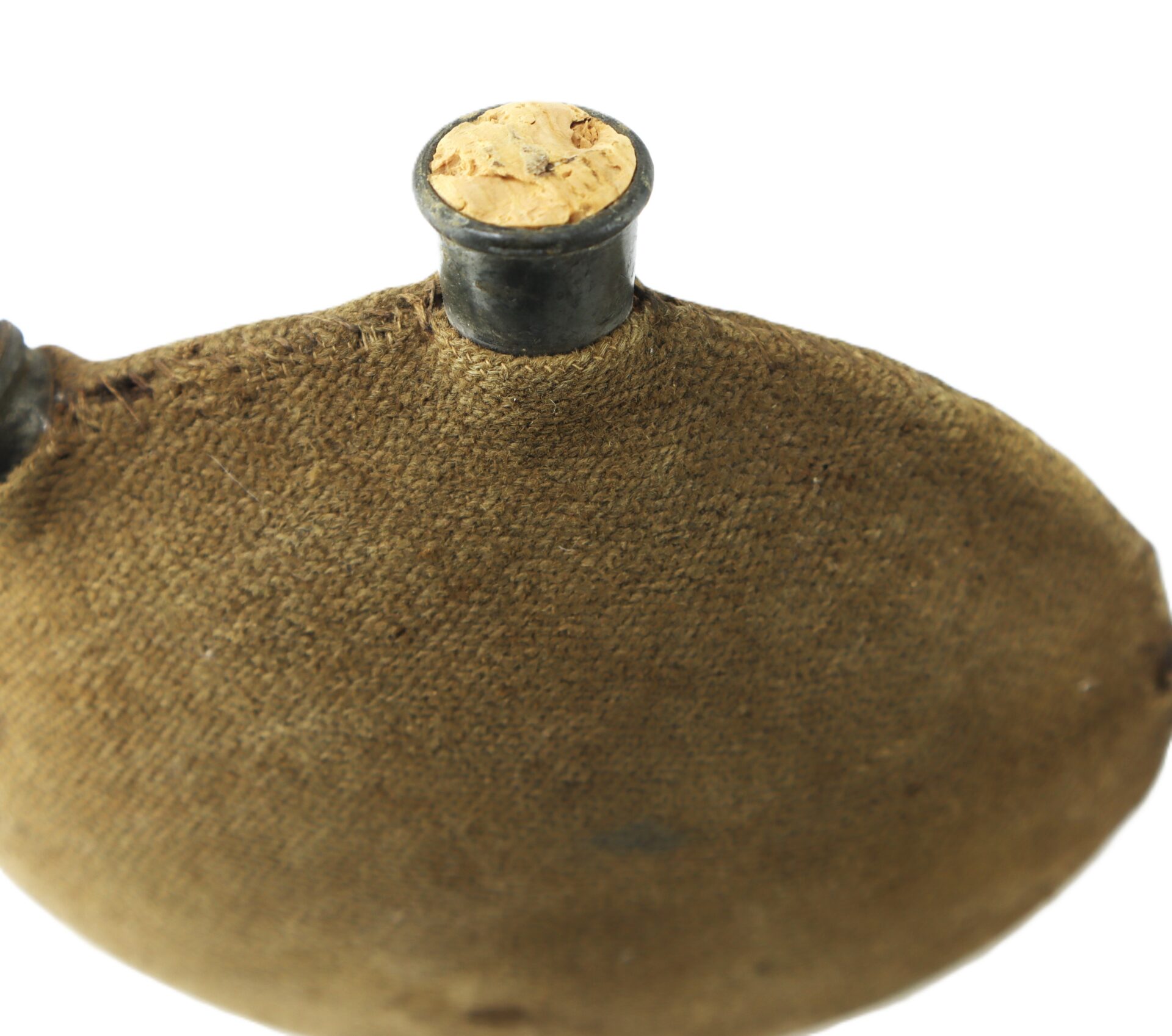 A close-up of an old canteen covered in brown fabric with a cork stopper in its metal neck, set against a white background.