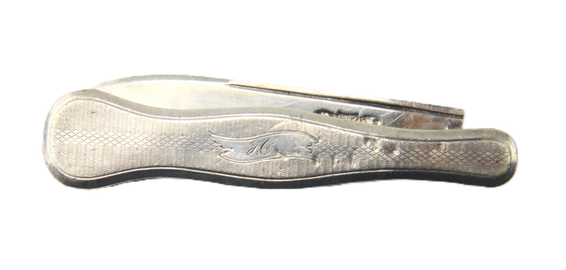 A closed vintage straight razor with a textured metal handle and engraved design, photographed on a white background.