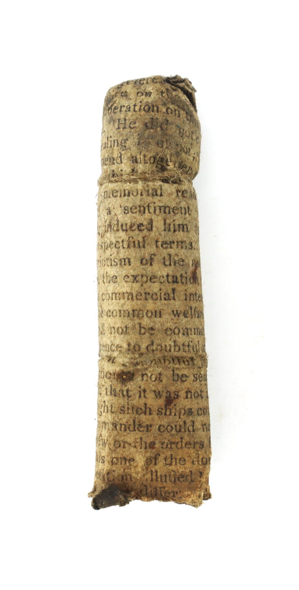 A small, cylindrical object wrapped in aged, printed paper with faded, partially readable text on a white background.