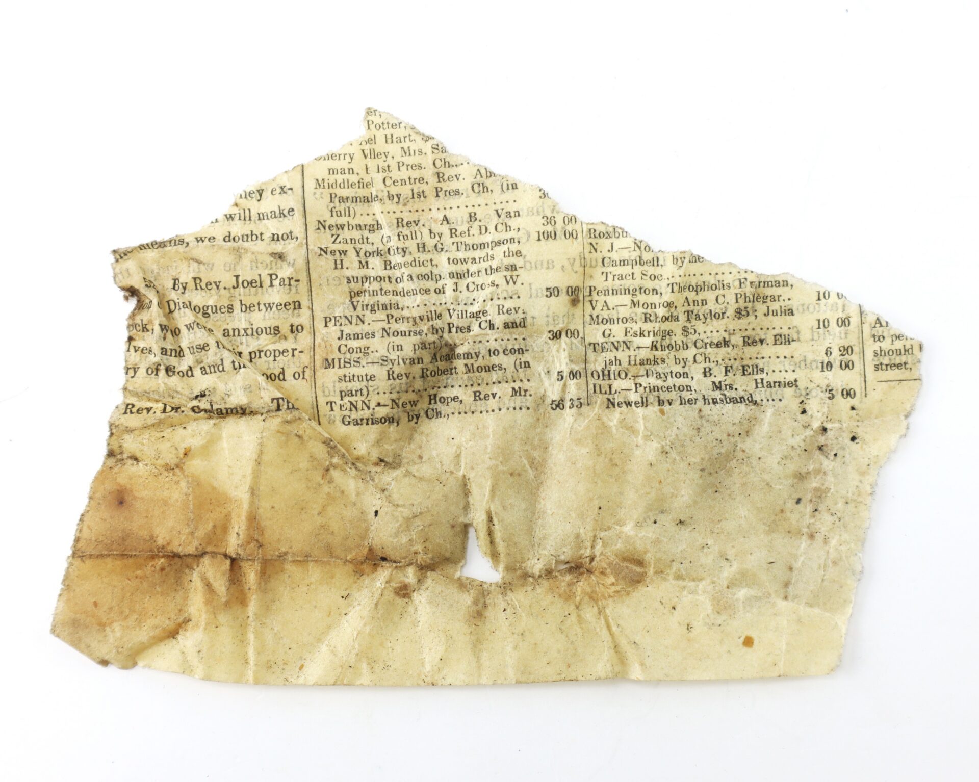 Torn, stained piece of old newspaper with partially visible printed text and a small hole in the center.