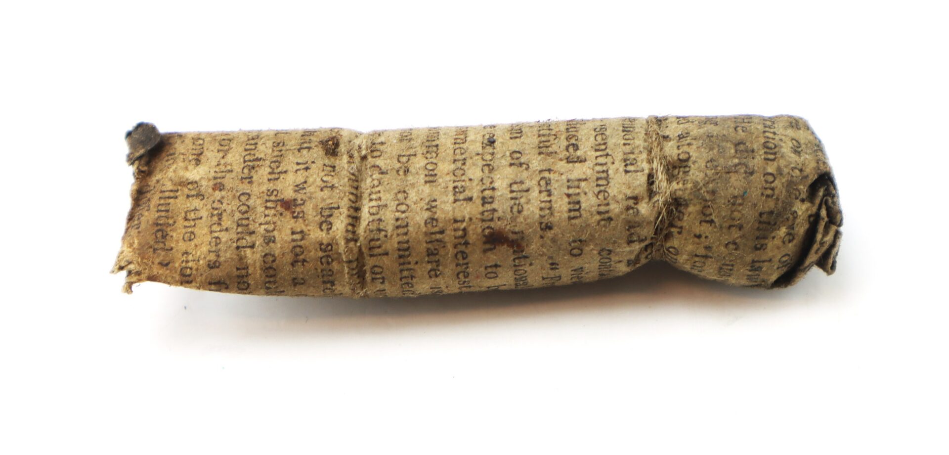 A small, aged piece of paper rolled into a cylinder, printed with faded text, resting on a white background.