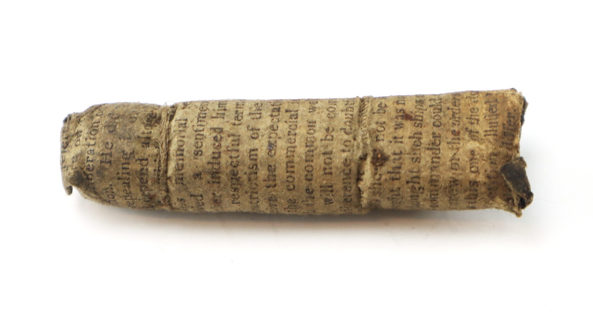 A small, rolled piece of aged paper with faded, printed text visible on its surface, isolated on a white background.
