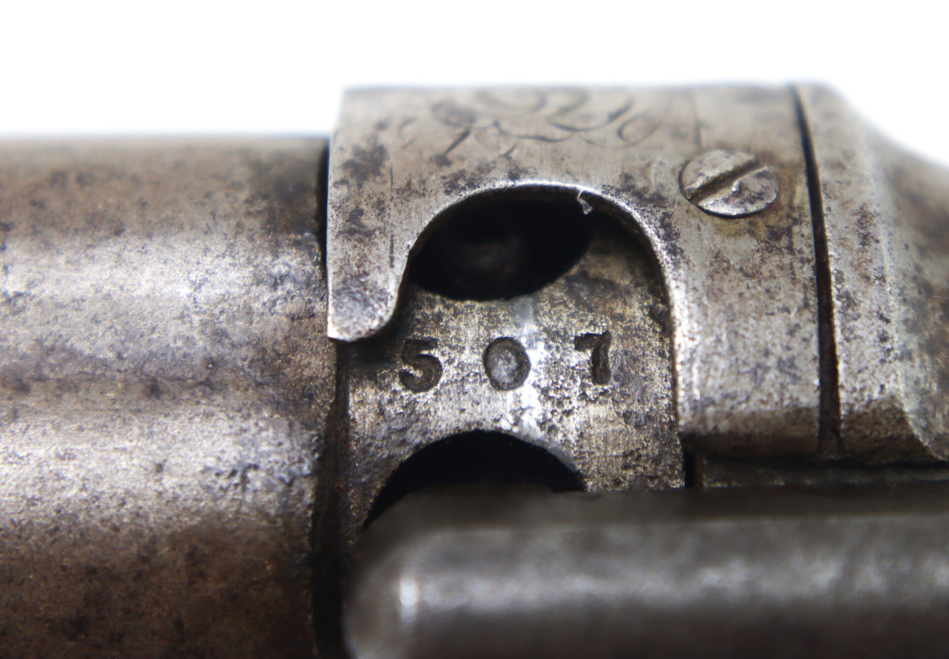 Close-up view of a metal firearm part showing engraved serial number “507” and visible machining details.