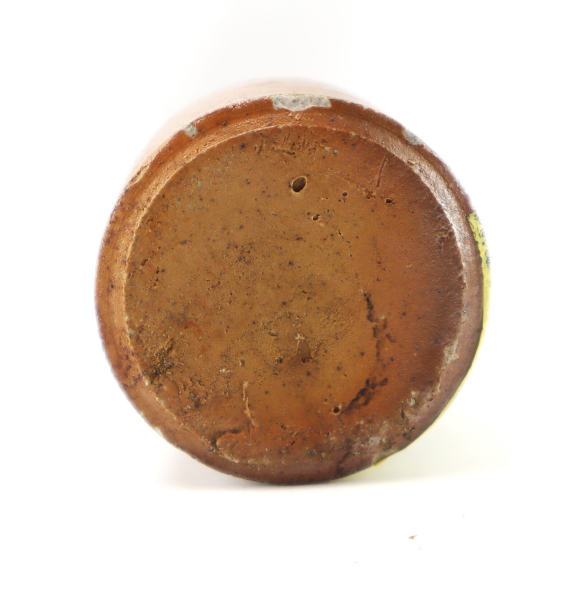 Bottom view of a circular, brown earthenware crock.