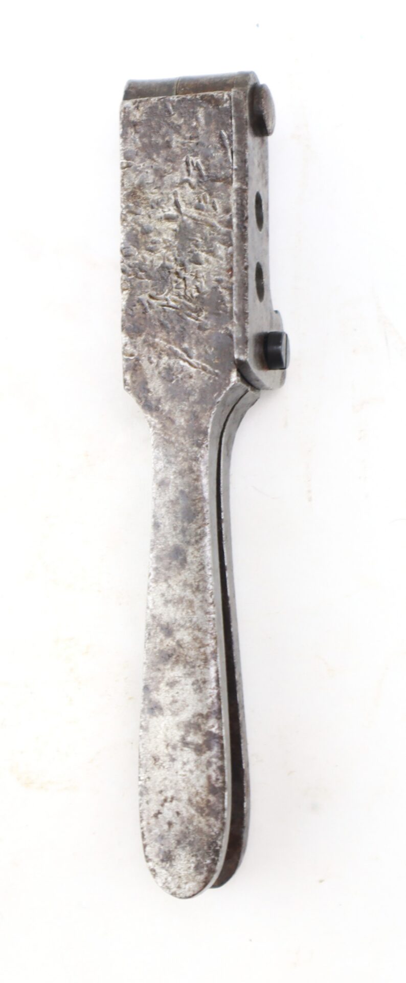 A vintage metal bullet mold with a handle and two circular cavities.