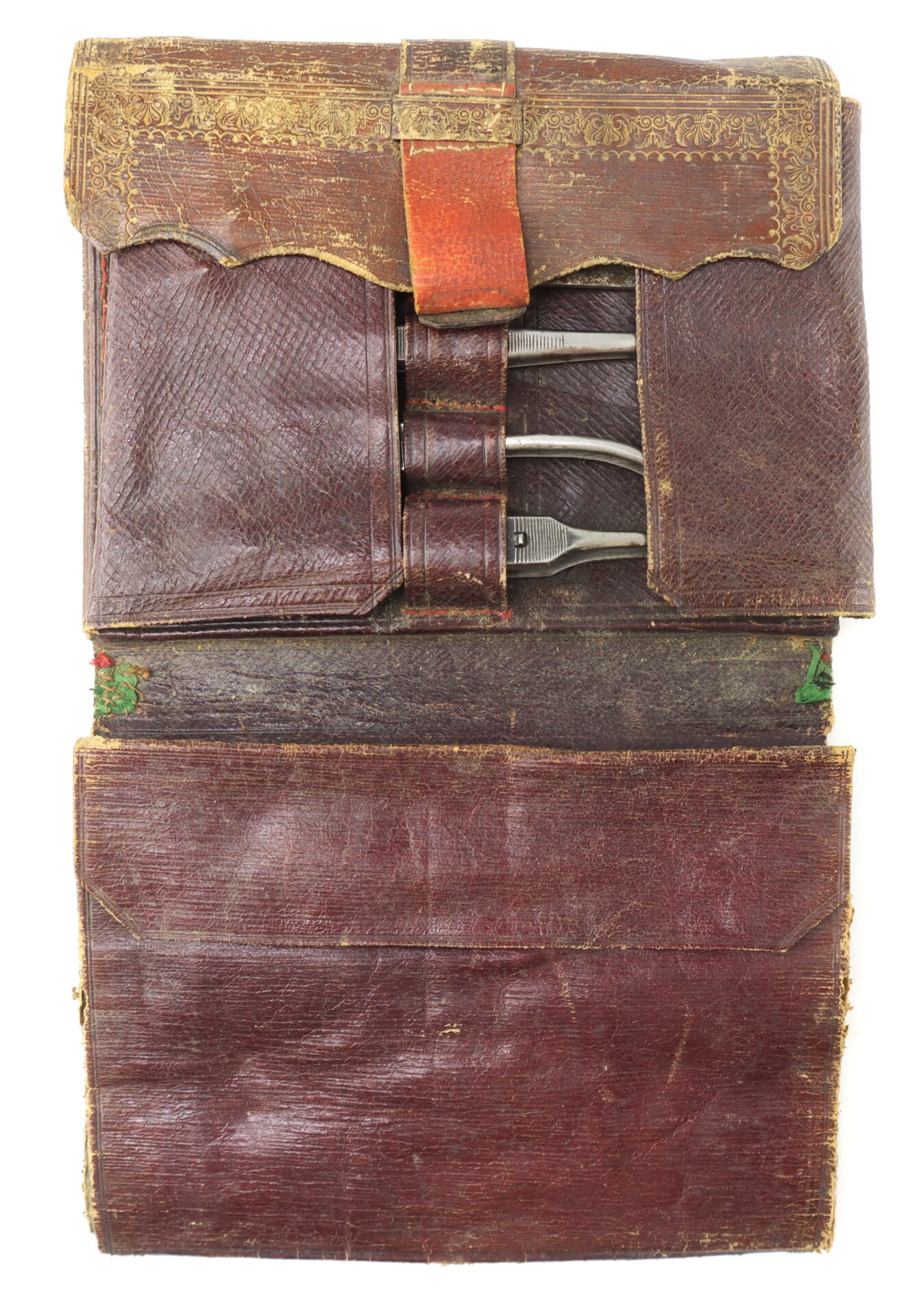 A vintage leather medical kit case containing three metal surgical instruments.