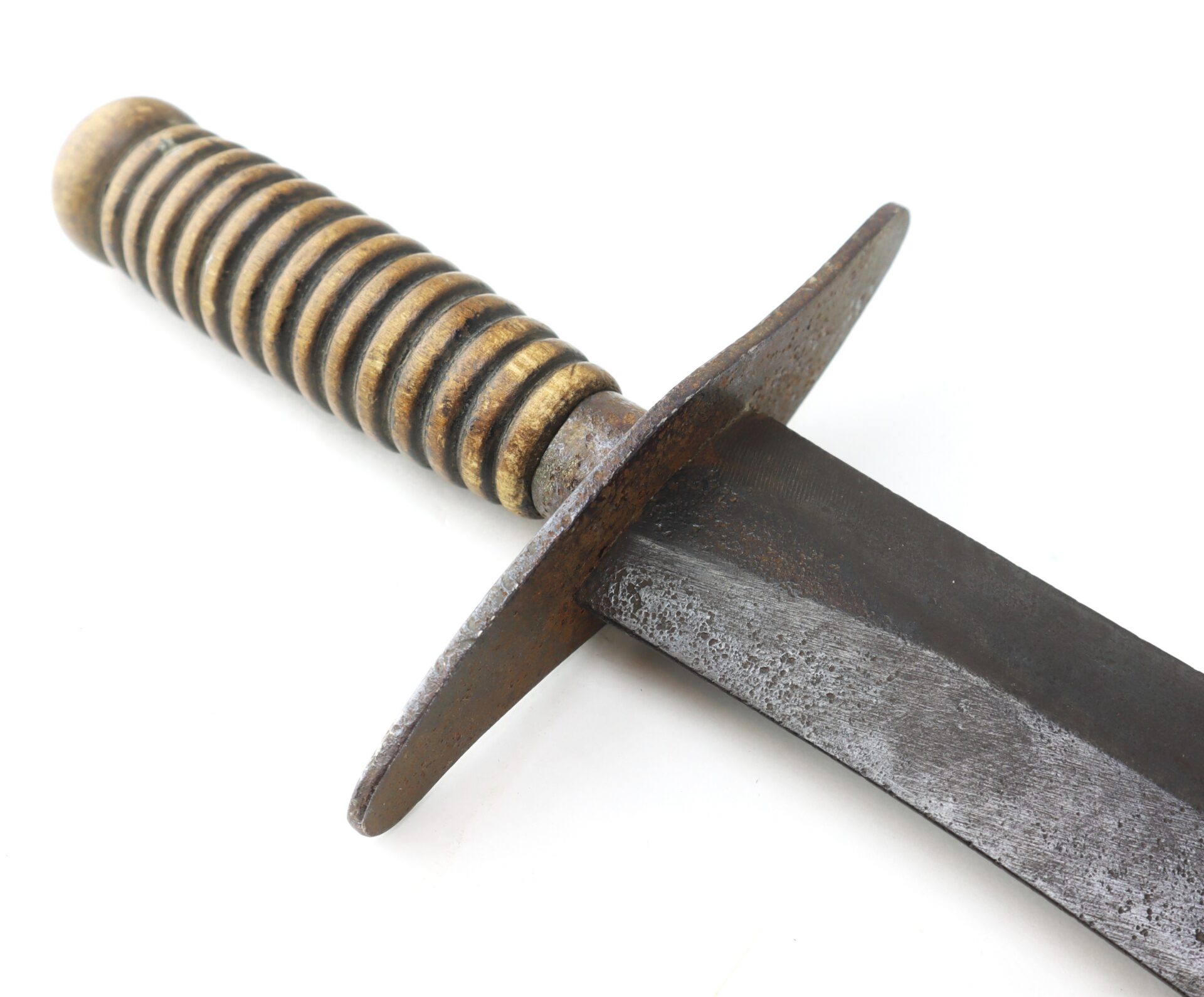 Close-up of a knife with a grooved handle and a wide, rusted crossguard.