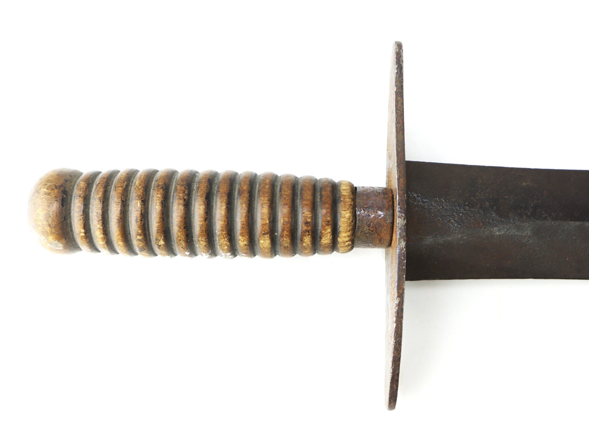 Close-up of a knife handle with a ribbed, cylindrical grip and a flat, metal crossguard.