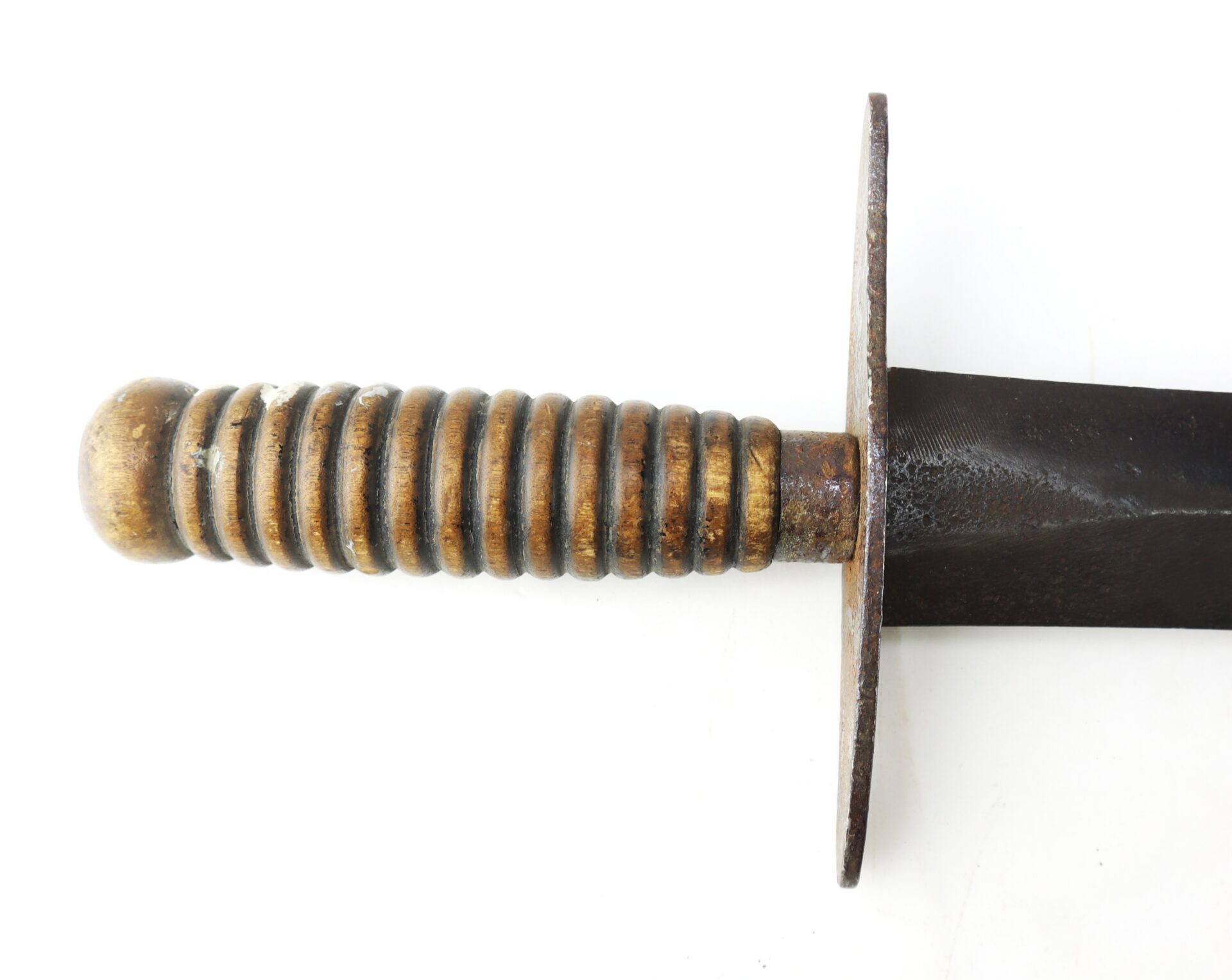 Close-up of a knife with a ridged wooden handle, a circular metal crossguard, and a dark metal blade.
