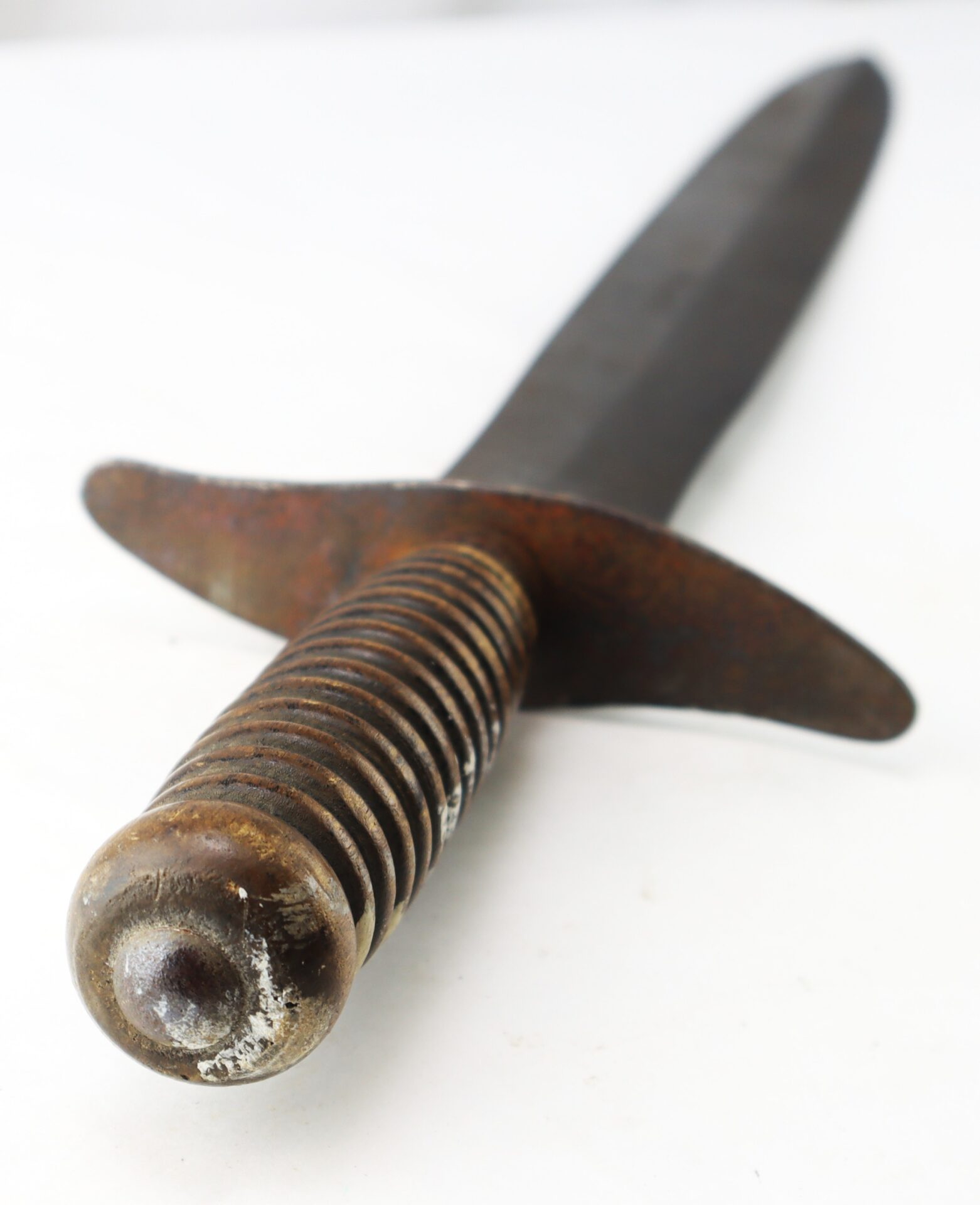 A dagger with a grooved metal handle and a dark, pointed blade.